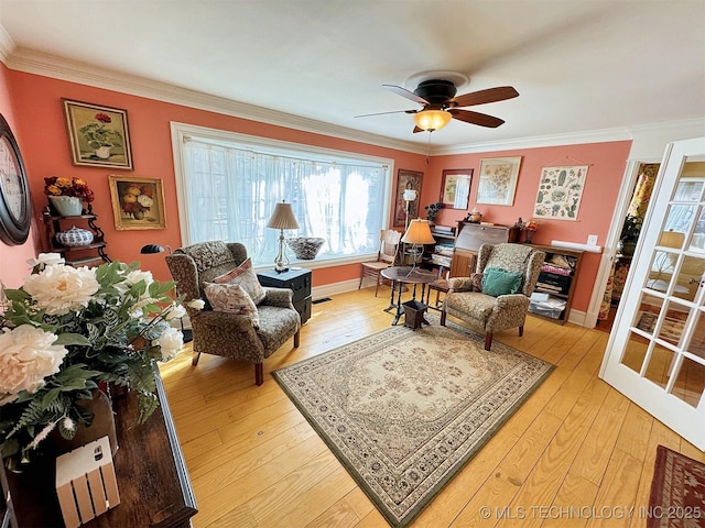 living area with ceiling fan, crown molding, and light hardwood / wood-style flooring