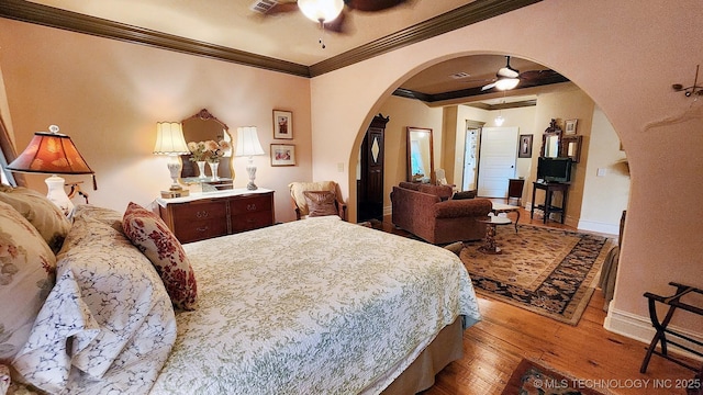 bedroom featuring ceiling fan, crown molding, and light hardwood / wood-style flooring