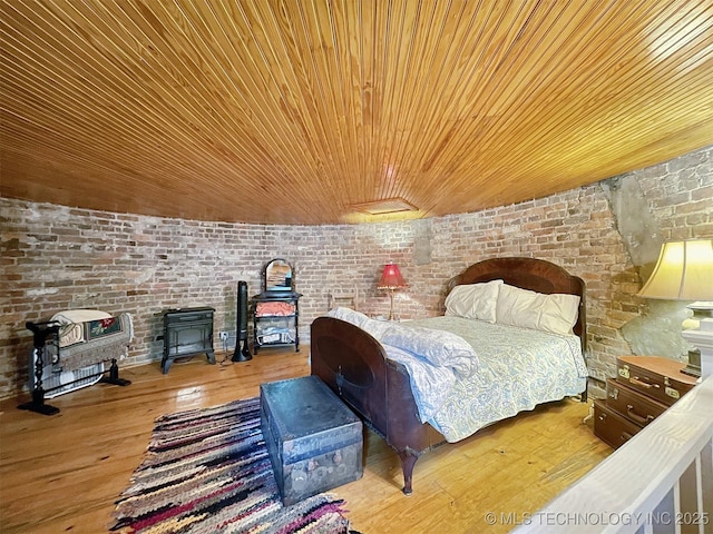 bedroom with hardwood / wood-style floors, wood ceiling, and brick wall