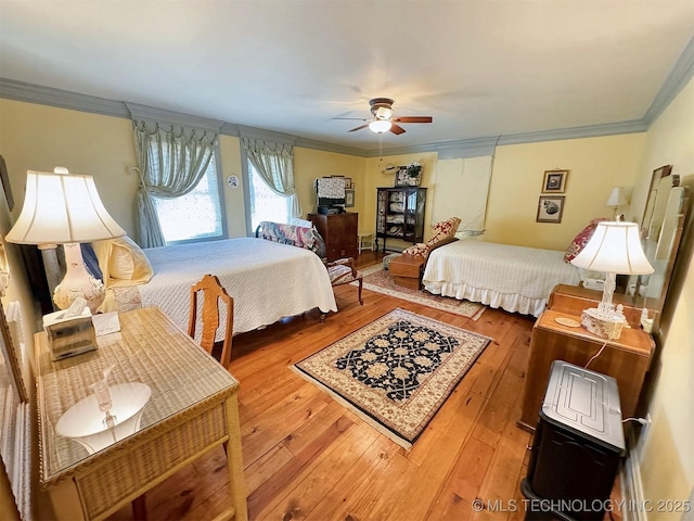 bedroom featuring ceiling fan, wood-type flooring, and crown molding