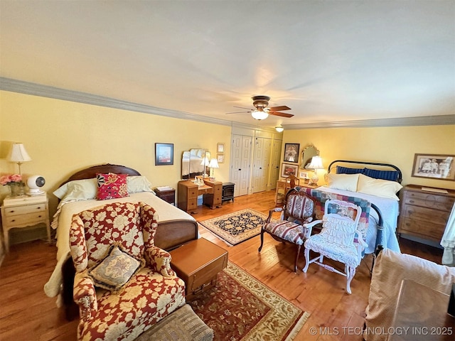 bedroom featuring hardwood / wood-style flooring, ceiling fan, and crown molding