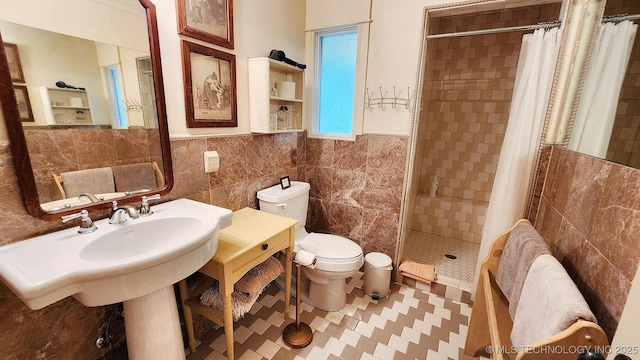 bathroom featuring curtained shower, tile walls, and toilet