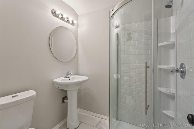 bathroom with tile patterned flooring, toilet, and walk in shower