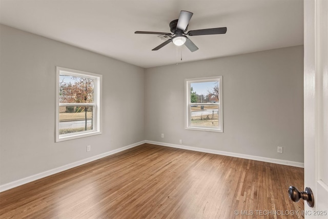 spare room featuring ceiling fan, plenty of natural light, and hardwood / wood-style floors