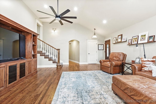 living room featuring dark hardwood / wood-style flooring, vaulted ceiling, and ceiling fan