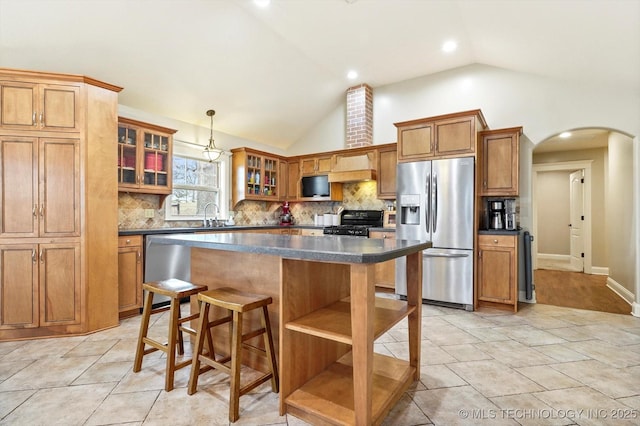 kitchen with a center island, sink, stainless steel appliances, and tasteful backsplash