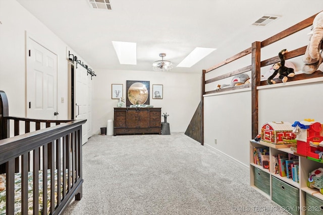 carpeted bedroom with a skylight and a nursery area