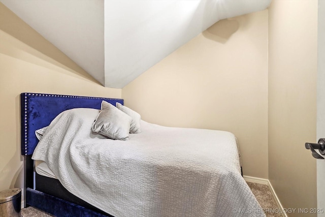 bedroom featuring lofted ceiling and carpet floors