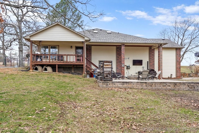 back of house featuring a lawn, a patio, and a wooden deck