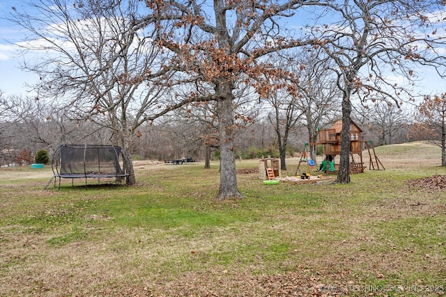 view of yard with a playground and a trampoline