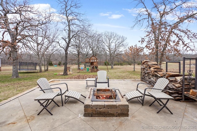 view of patio / terrace with a playground, a trampoline, and a fire pit