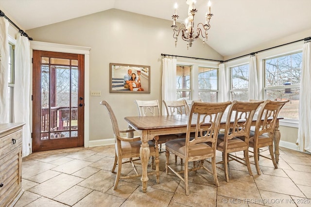 tiled dining area with plenty of natural light, lofted ceiling, and a notable chandelier