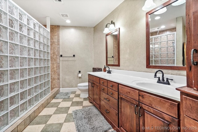 bathroom featuring vanity, toilet, and walk in shower