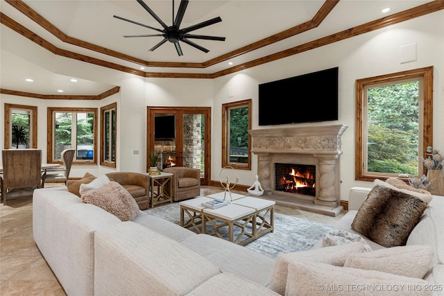 living room with ceiling fan, a premium fireplace, and crown molding