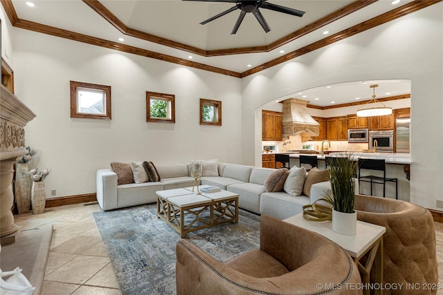 living room with a towering ceiling, ceiling fan, and ornamental molding