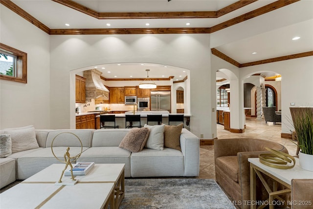 living room with ornamental molding, light tile patterned floors, and a towering ceiling