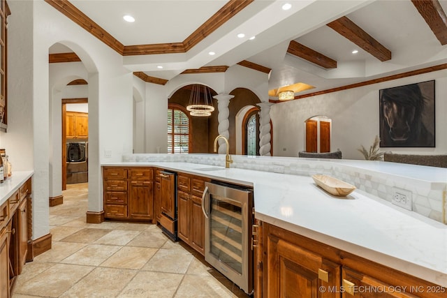 bathroom with backsplash, crown molding, beverage cooler, and washer / dryer