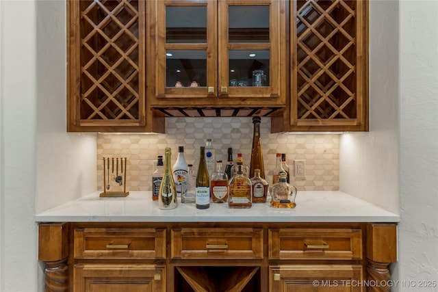 bar featuring decorative backsplash and light stone countertops