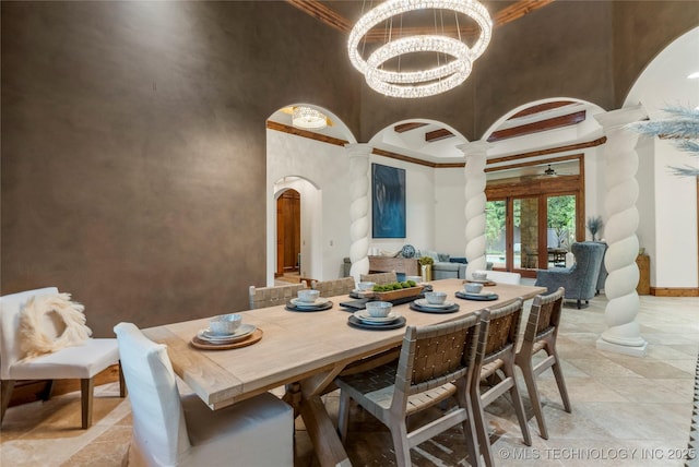 dining space featuring french doors, crown molding, a high ceiling, and a chandelier