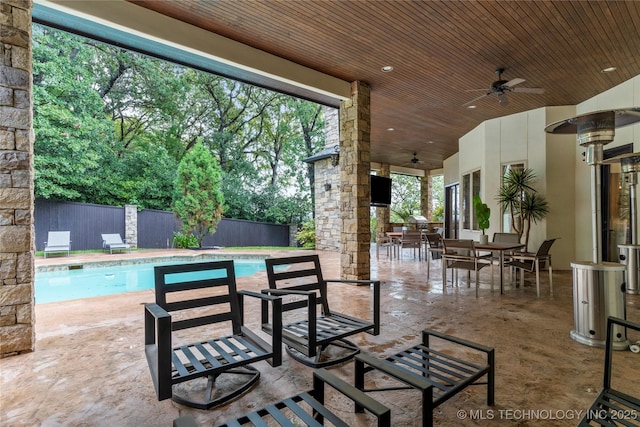 view of patio with ceiling fan and a fenced in pool