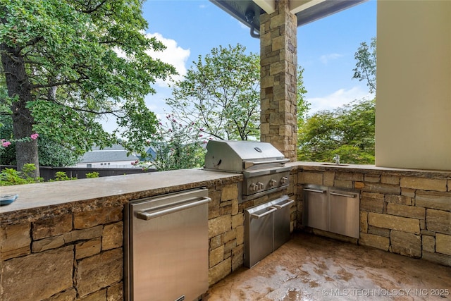 view of patio with area for grilling and a grill