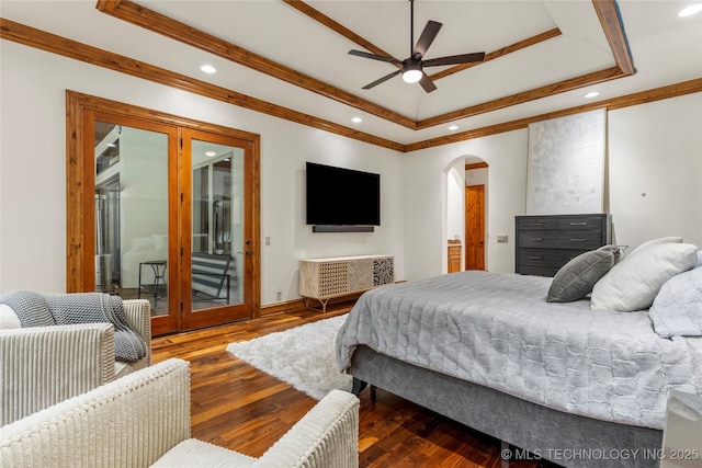 bedroom featuring dark wood-type flooring, access to outside, ceiling fan, ornamental molding, and a tray ceiling