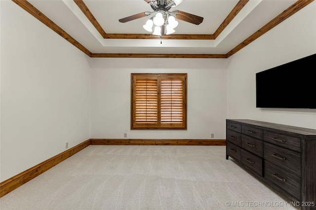 carpeted bedroom featuring ceiling fan, crown molding, and a tray ceiling