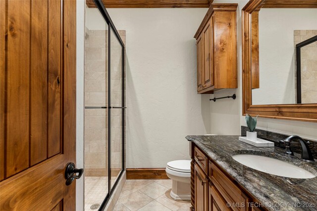 bathroom featuring tile patterned flooring, vanity, toilet, and walk in shower