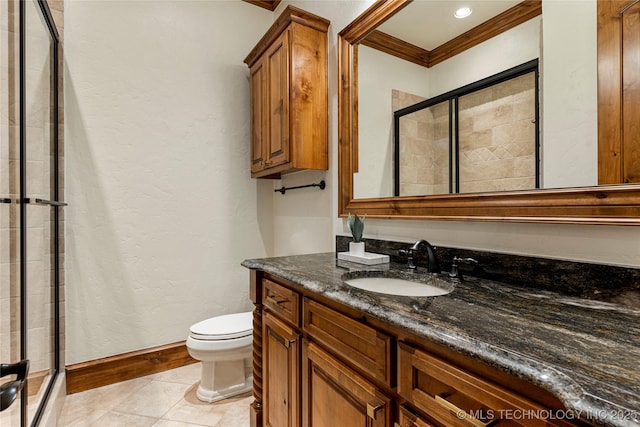 bathroom with vanity, toilet, a shower with shower door, and ornamental molding