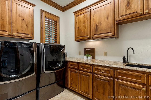 clothes washing area with sink, cabinets, crown molding, light tile patterned floors, and washer and dryer