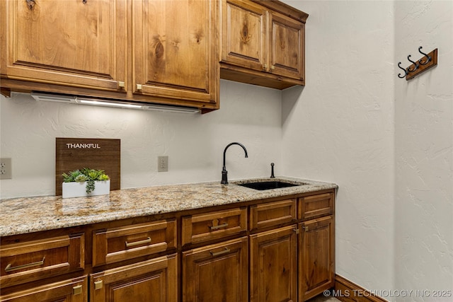 kitchen with light stone counters and sink