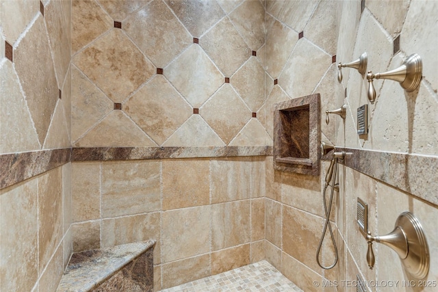 interior details featuring a tile shower