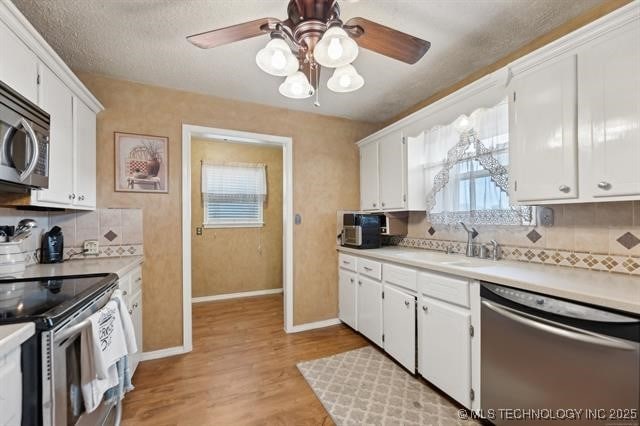 kitchen with sink, white cabinetry, appliances with stainless steel finishes, and tasteful backsplash