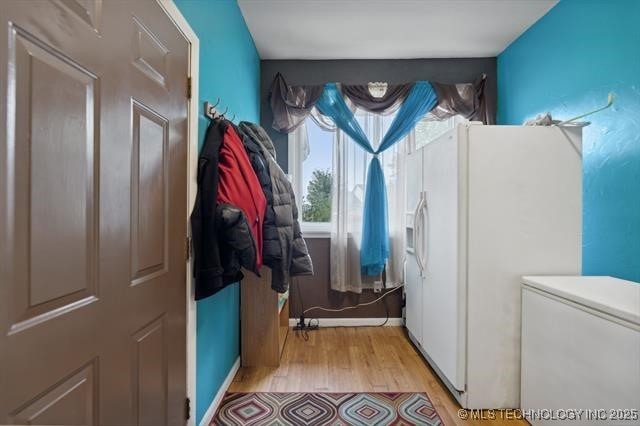 clothes washing area featuring light hardwood / wood-style floors