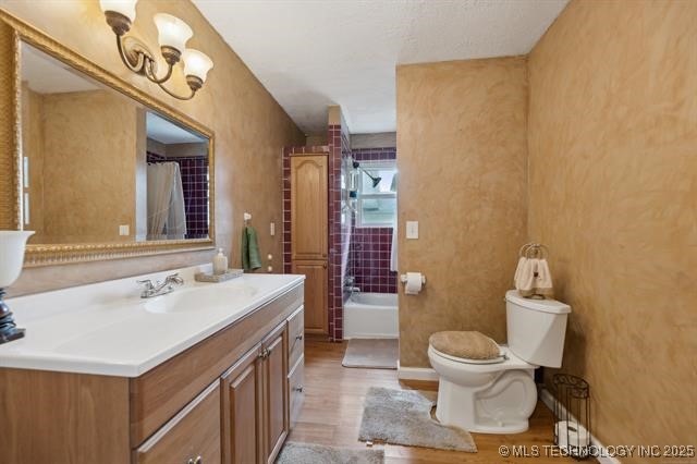 full bathroom with wood-type flooring, toilet, shower / tub combo, and vanity