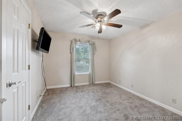 carpeted empty room with ceiling fan and a textured ceiling