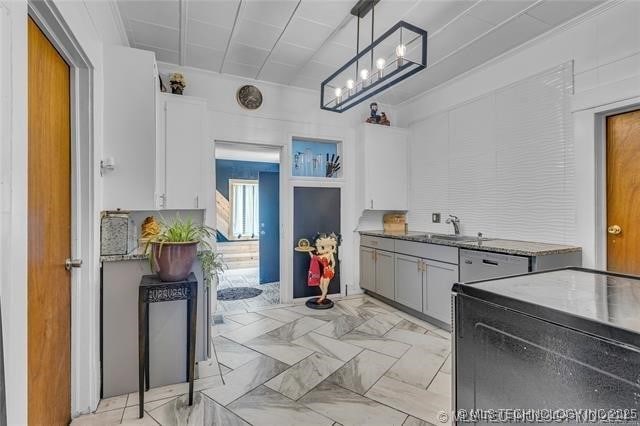 kitchen featuring pendant lighting, white cabinets, and sink