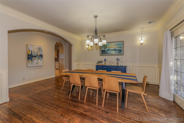 dining room featuring dark hardwood / wood-style floors, an inviting chandelier, and ornamental molding