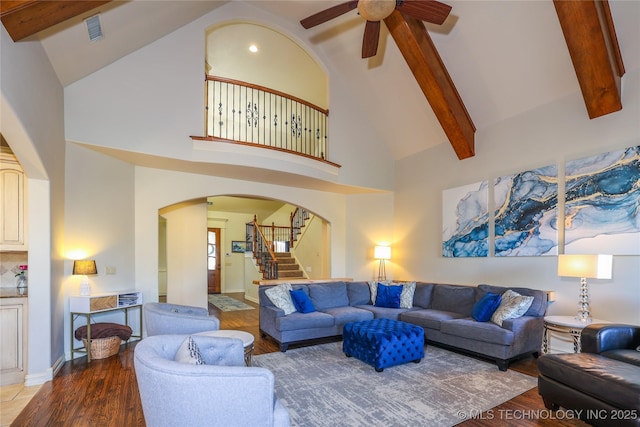 living room with beamed ceiling, hardwood / wood-style flooring, high vaulted ceiling, and ceiling fan