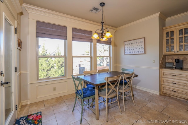 dining space featuring ornamental molding and a chandelier