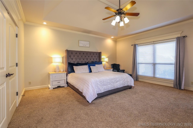 bedroom featuring a raised ceiling, ceiling fan, carpet floors, and ornamental molding