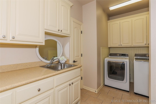 laundry area featuring light tile patterned flooring, cabinets, separate washer and dryer, and sink