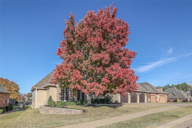 obstructed view of property featuring a garage and a front yard