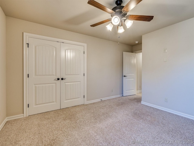 unfurnished bedroom with ceiling fan, light carpet, and a closet