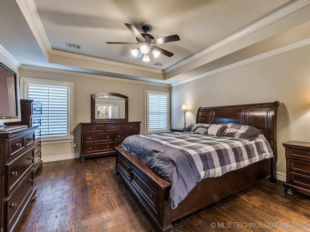 bedroom with dark hardwood / wood-style flooring, a tray ceiling, ceiling fan, and crown molding