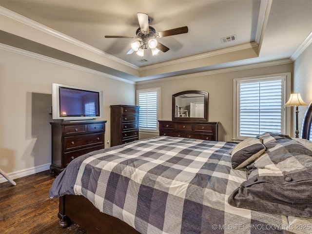 bedroom with a tray ceiling, ceiling fan, ornamental molding, and dark hardwood / wood-style floors