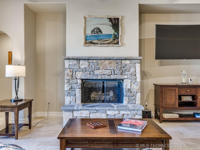 living room featuring a stone fireplace