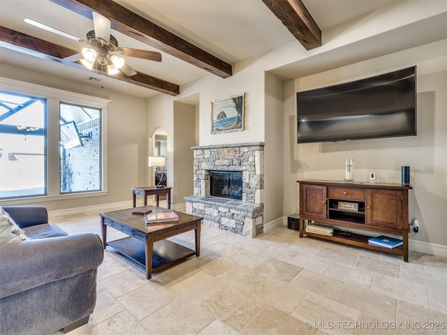 living room featuring a fireplace, ceiling fan, and beamed ceiling