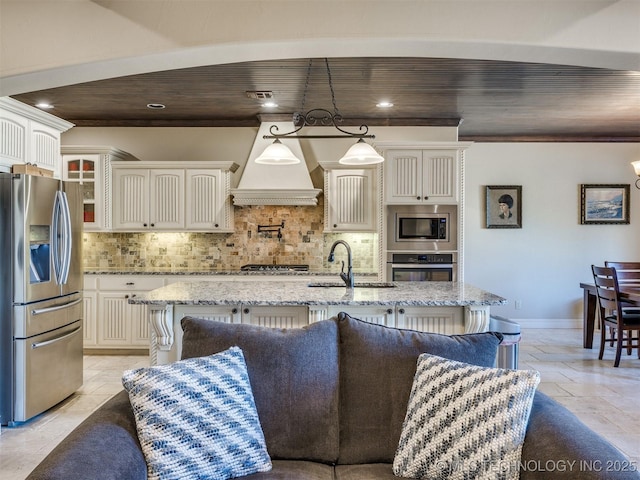 kitchen featuring tasteful backsplash, premium range hood, wood ceiling, stainless steel appliances, and sink