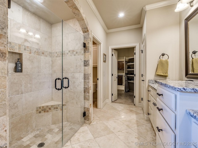 bathroom with vanity, toilet, a shower with door, and ornamental molding